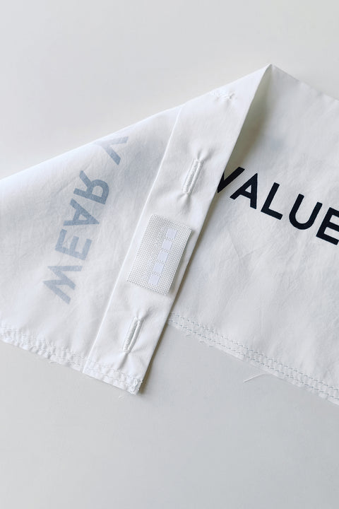Detail. The White Canvas white cotton poplin fabric panel made from leftover deadstock fabrics and with black patch and artisanal eco-friendly screen print done locally in Paris in collaboration with RoStudio. Attach the panel to the essential pieces to personalize them and wear them your unique way