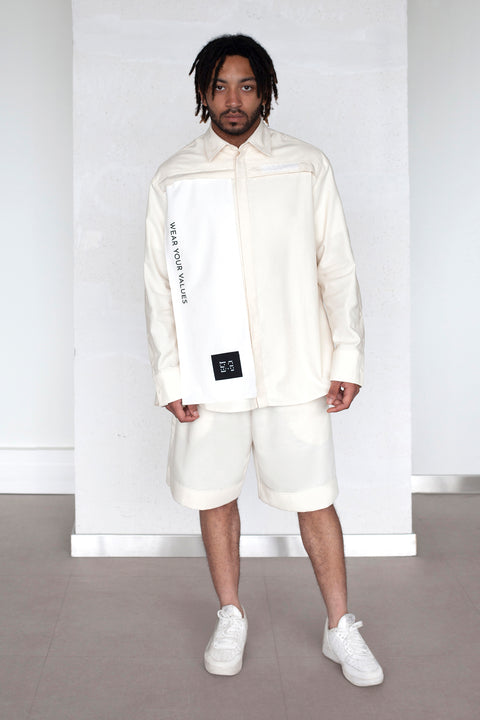 The White Canvas ESSENTIAL SHIRT with white cotton poplin fabric panel made from leftover deadstock fabrics and with black patch and artisanal eco-friendly screen print done locally in Paris in collaboration with RoStudio. Attach the panel to the essential pieces to personalize them and wear them your unique way