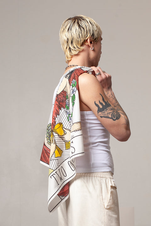 THE TWO OF CUPS foulard and square panel is made from leftover deadstock silk fabric The foulard has an exclusive design inspired by tarot cards drawn by the artist Maria Robla, printed with black artisanal eco-friendly ink locally in Paris and hand painted by the artist. Wear the foulard alone or attach it to the essential pieces to personalize them and wear them your unique way. Your perfect summer accessory. White Canvas x Maria Robla.