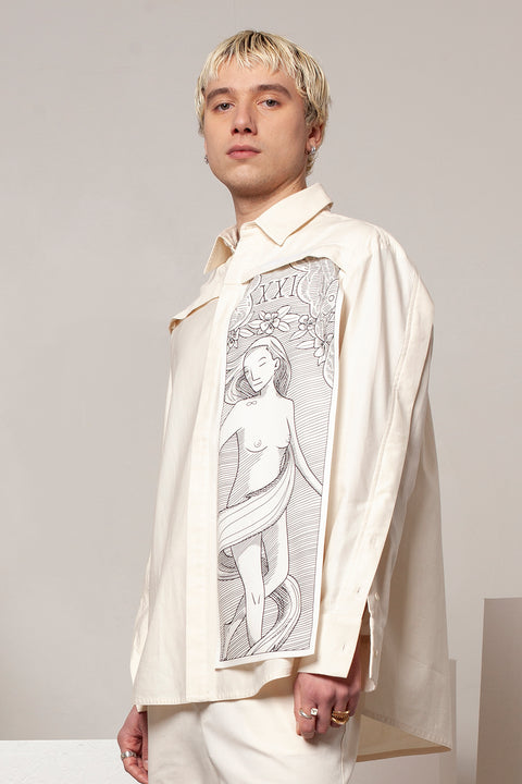 Clément is wearing the White Canvas ESSENTIAL SHIRT styled with THE WORLD vertical panel made from leftover deadstock white cotton poplin. The panel has an exclusive design inspired by tarot cards drawn by the artist Maria Robla and printed with black artisanal eco-friendly ink locally in Paris in collaboration with RoStudio. Attach the black and white panel to the essential pieces to personalize them and wear them your unique way. Your perfect summer accessory.